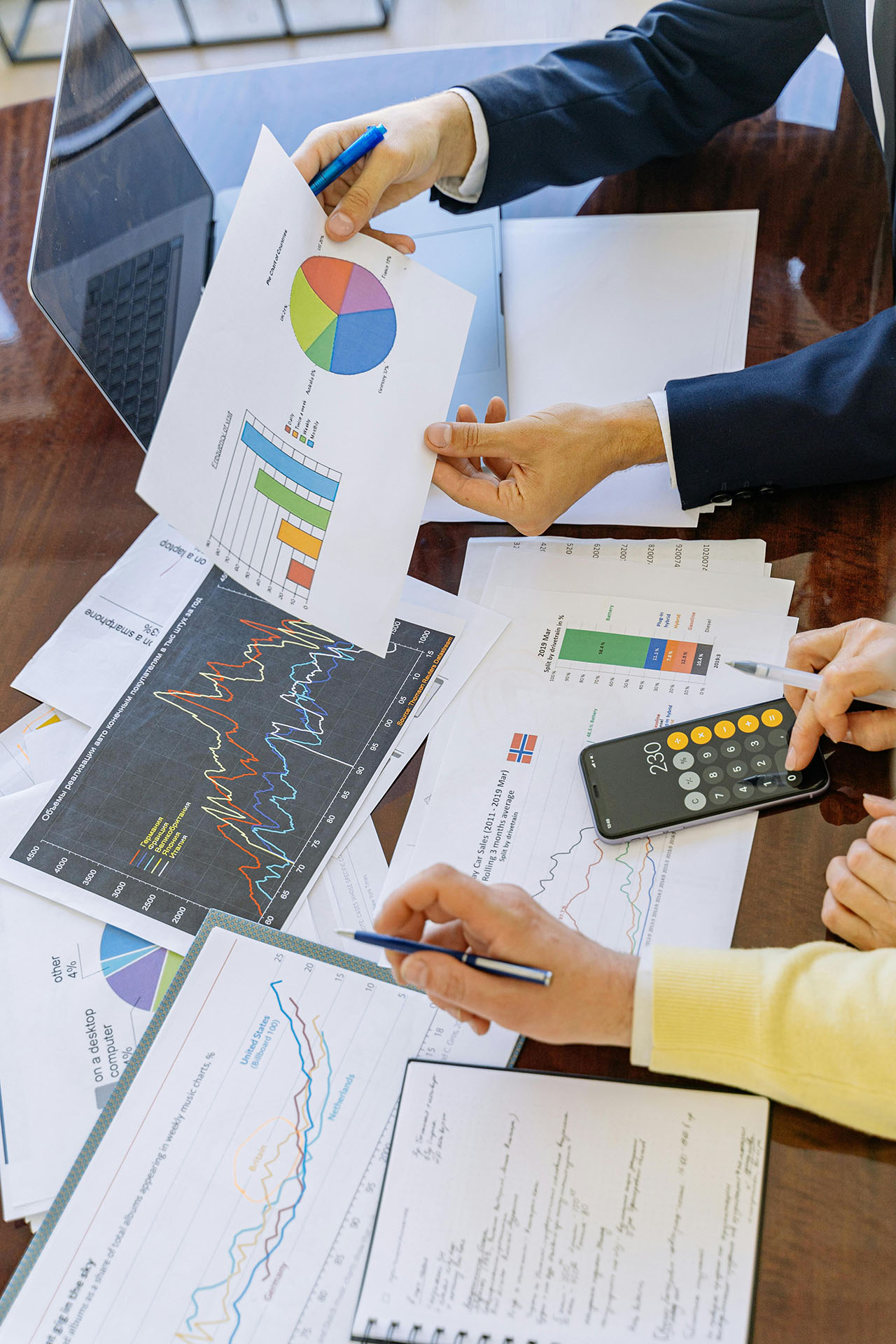 A group sitting around desk looking at charts and trends