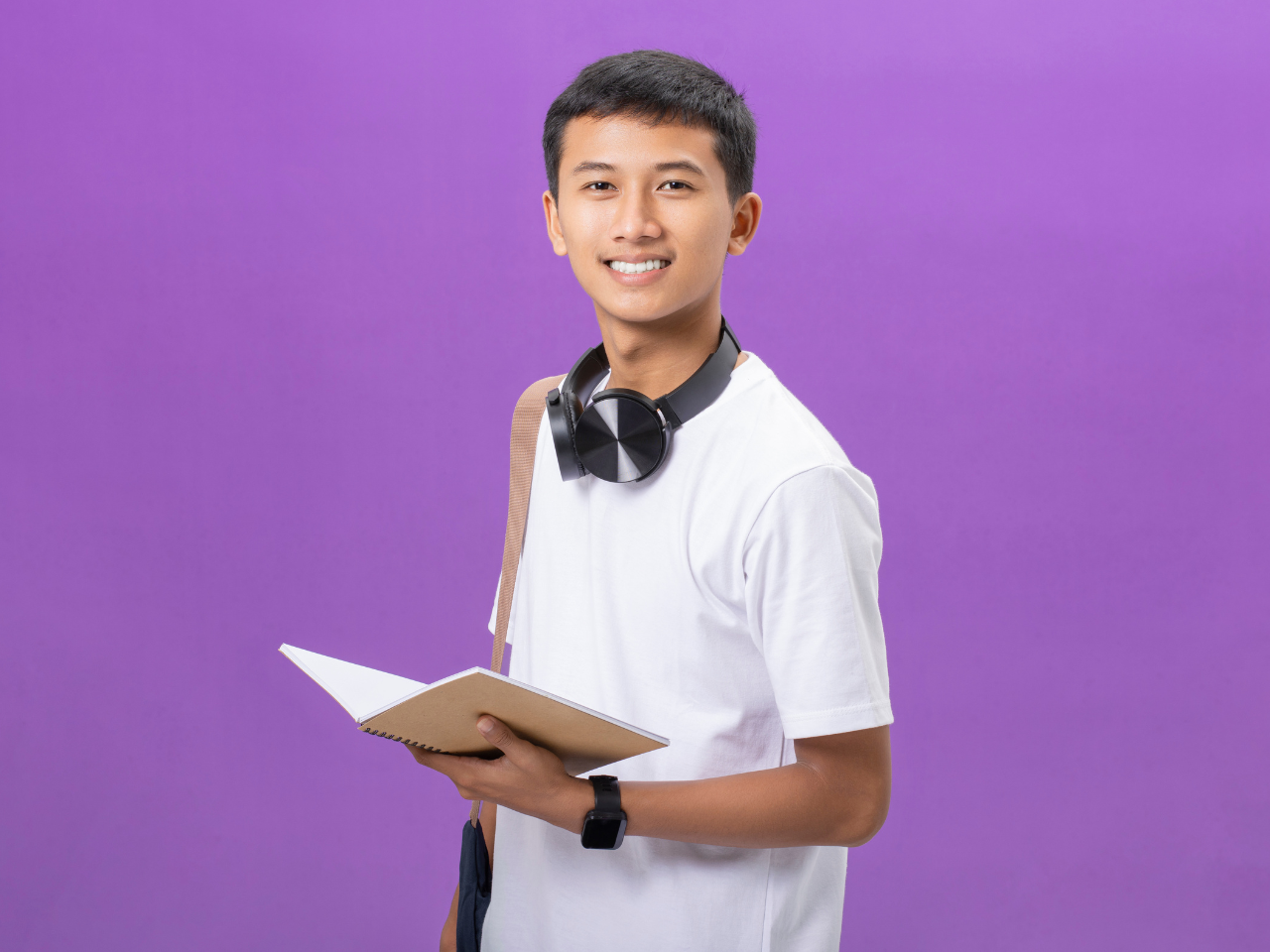 teen boy student with backpack on and headphones around their neck.